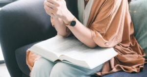 Mulher em robe marrom sentada em sofá preto