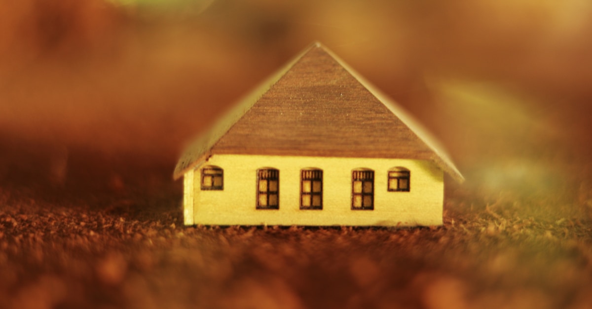 Descrição: miniatura de casa de madeira marrom em solo marrom