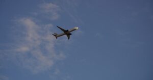 Descrição: um grande avião a jato voando pelo céu azul