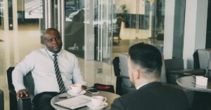 Dois empresários conversando na mesa de um café