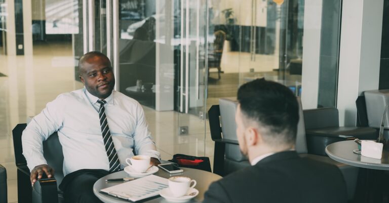 Dois empresários conversando na mesa de um café