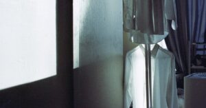 Camisas brancas penduradas em um quarto mal iluminado