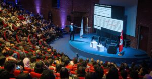 Palestrante apresentando para um grande público em um auditório