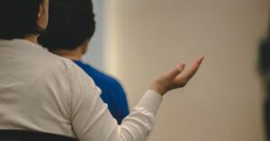 Mulher gesticulando com a mão em uma reunião