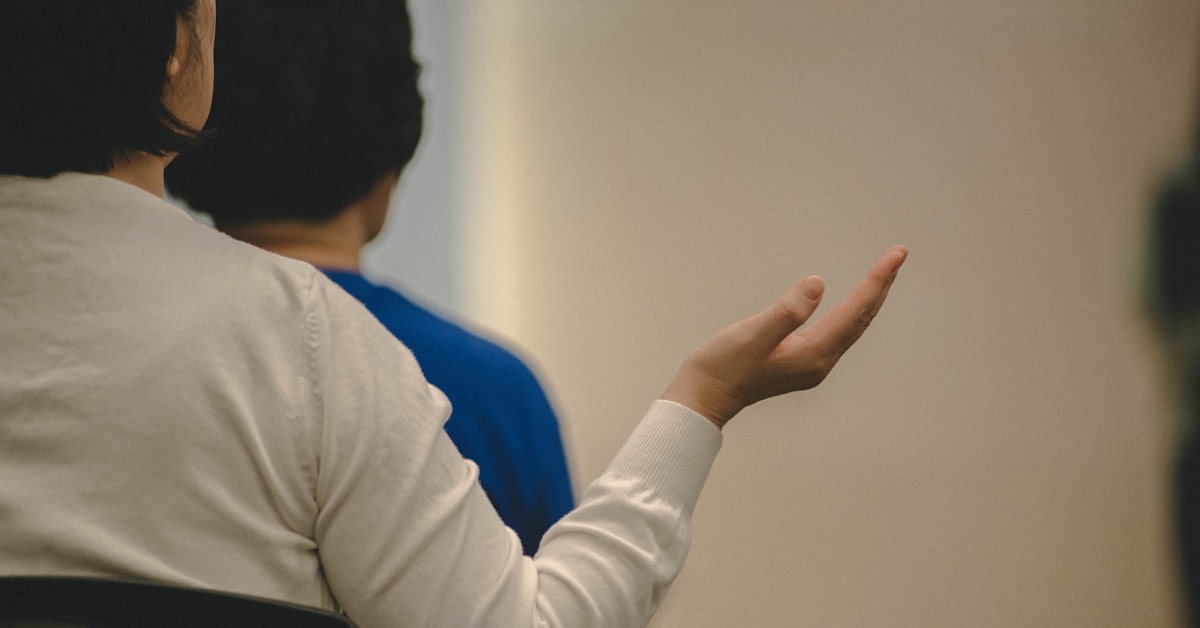 Mulher gesticulando com a mão em uma reunião