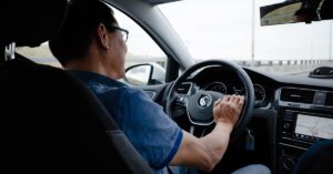 um homem dirigindo um carro em uma rodovia